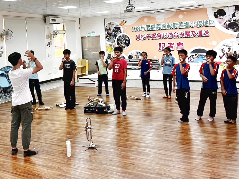 嘉大音樂學系學生教導大埔國中小學童吹奏小號樂器。（照片由音樂系提供）