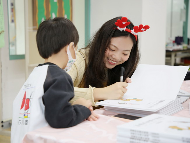 嘉大應化系系友兼繪本作者蔡佩珊回嘉為每位幼童的新書上簽名留念
