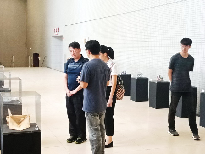 嘉大應用數學系嚴志弘副教授(前)向參觀民眾解說展覽作品