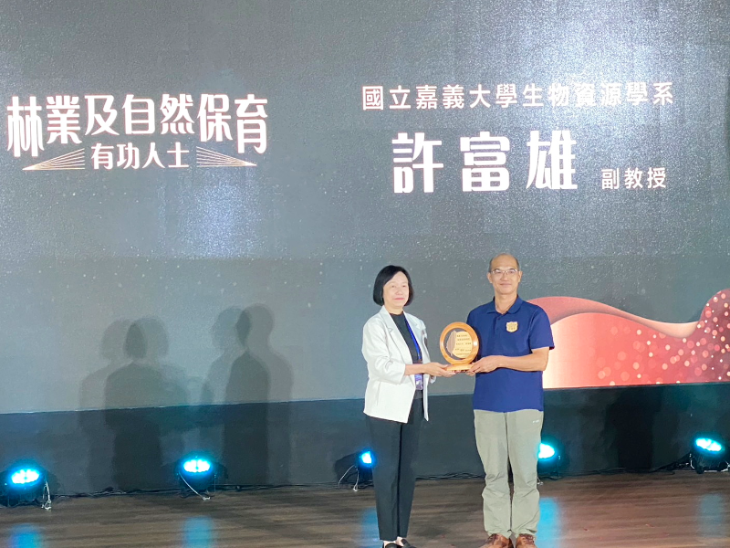 農業部次長杜文珍頒獎予嘉大生物資源學系許富雄副教授(右)。(照片由生資系辦提供)