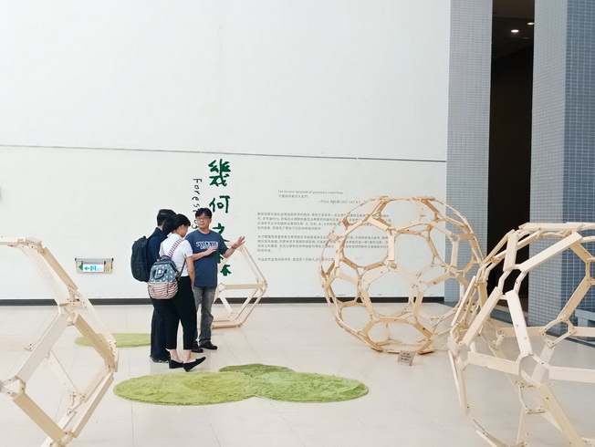 嘉大應用數學系嚴志弘副教授(右)向參觀民眾解說展覽作品