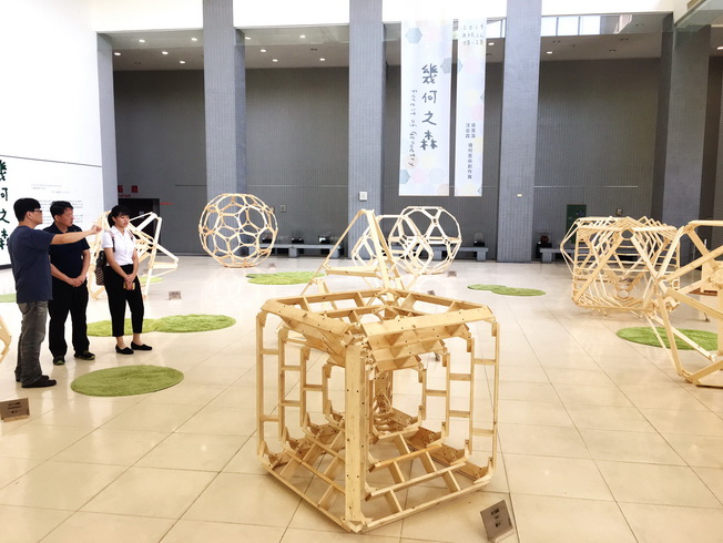 嘉大應用數學系嚴志弘副教授(左)向參觀民眾解說展覽作品